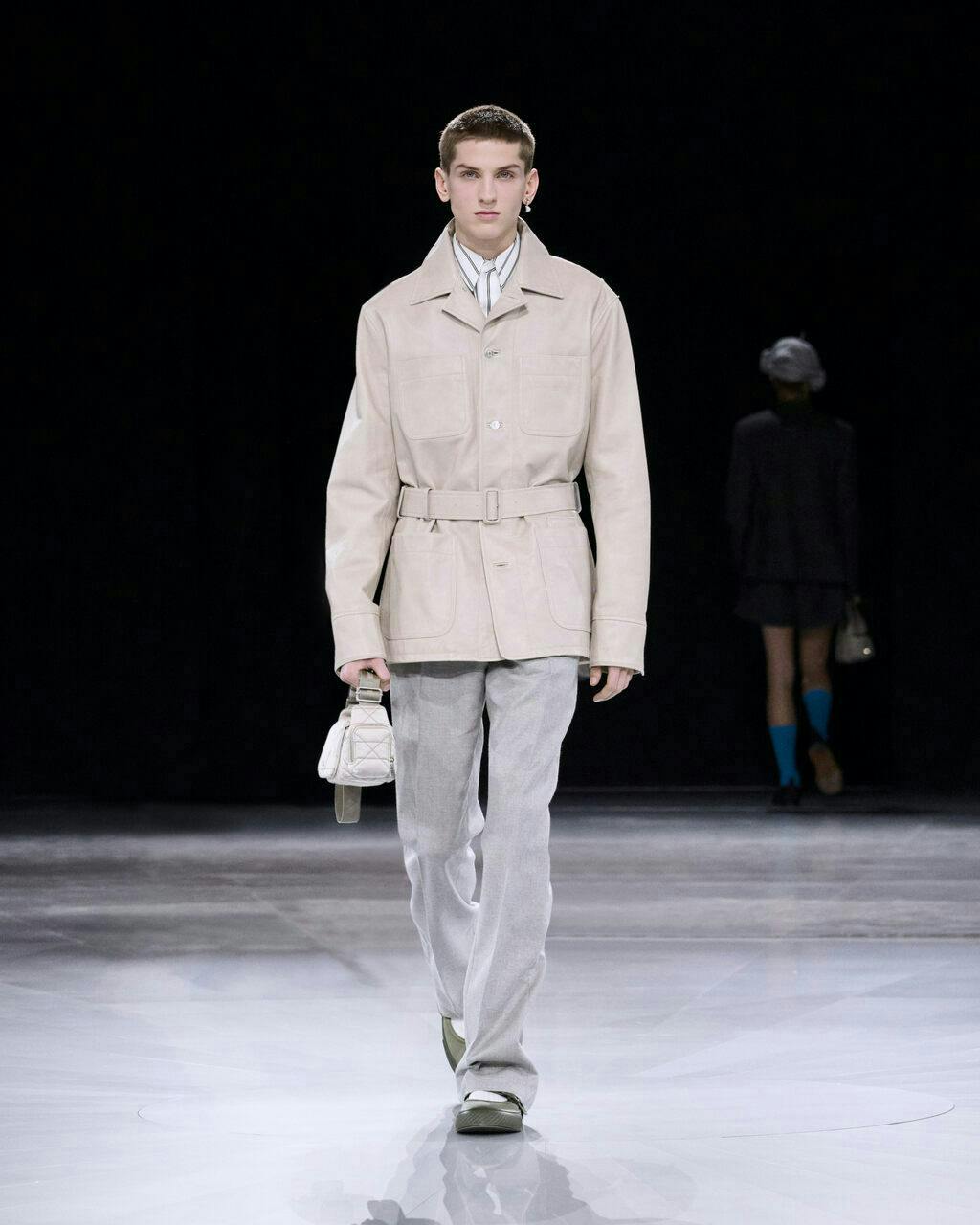 coat fashion adult male man person long sleeve handbag standing pants