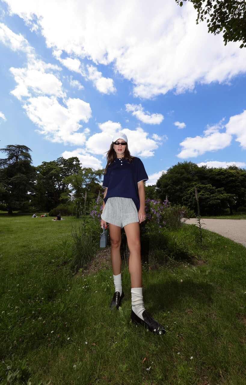 female girl person teen skirt shorts standing grass miniskirt shoe